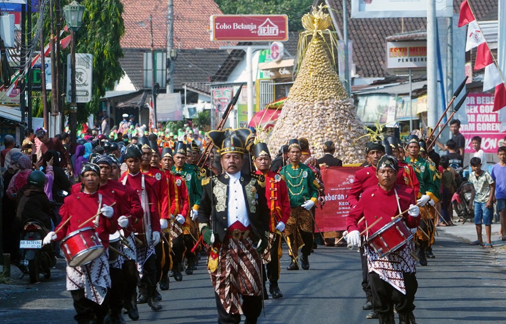 TRADISI - Kirab Gunungan apem kukus keong mas melewati jalan sekitar Pengging, Banyudono.